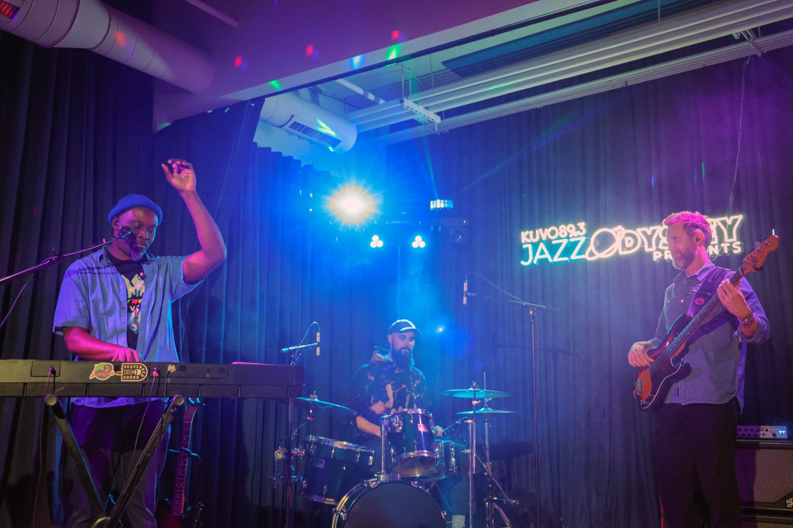 The band performing in front of the Jazz Odyssey neon sign